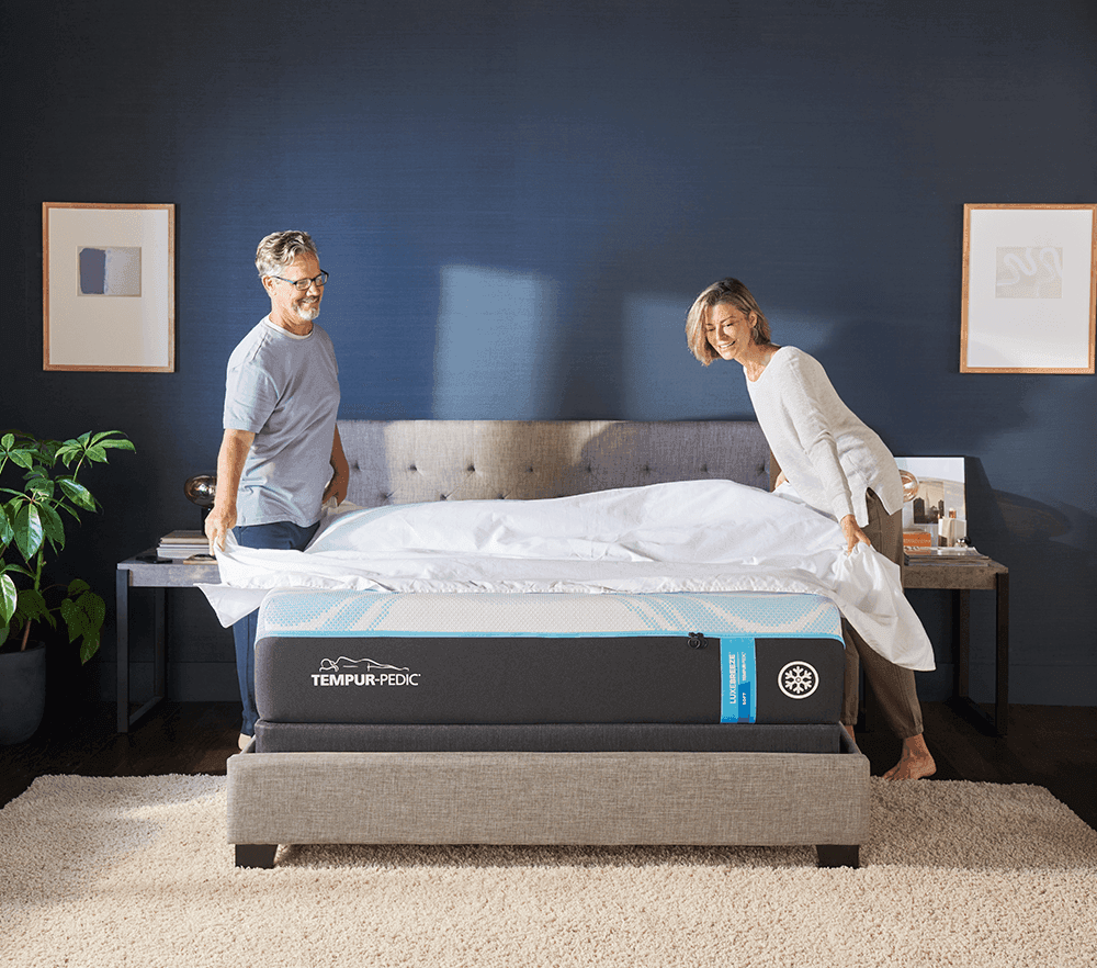 two people dressing a bed